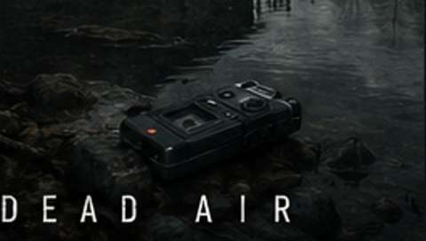 Portable recorder resting on wet rocks beside dark water beneath the Dead Air mark; no person, grave marker, or apparition is visible.